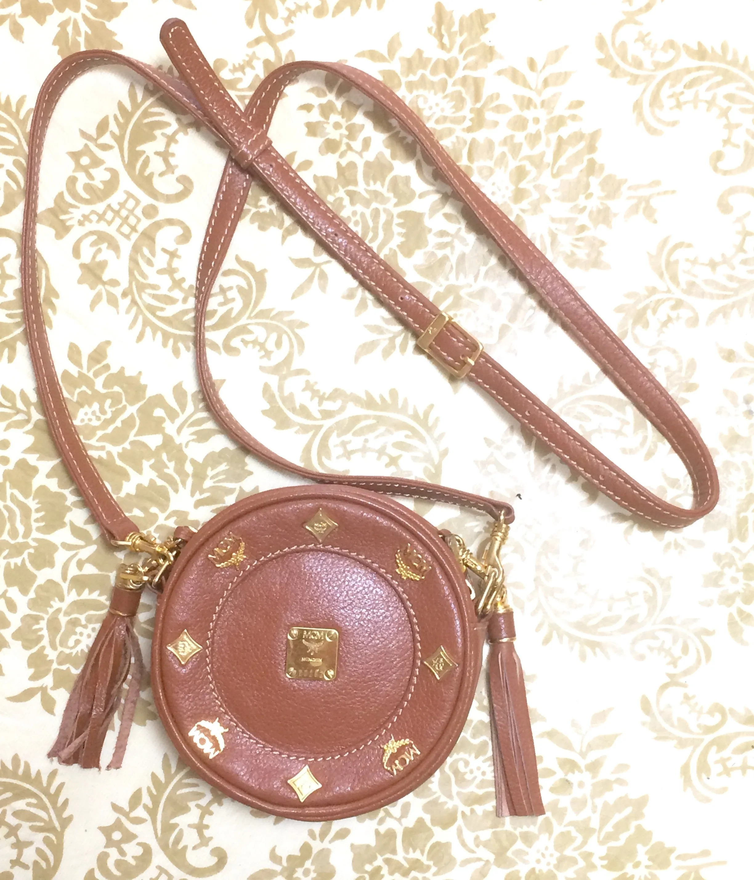 Vintage MCM brown leather round mini Suzy Wong shoulder bag with golden logo motifs. trimmings. Designed by Michael Cromer.