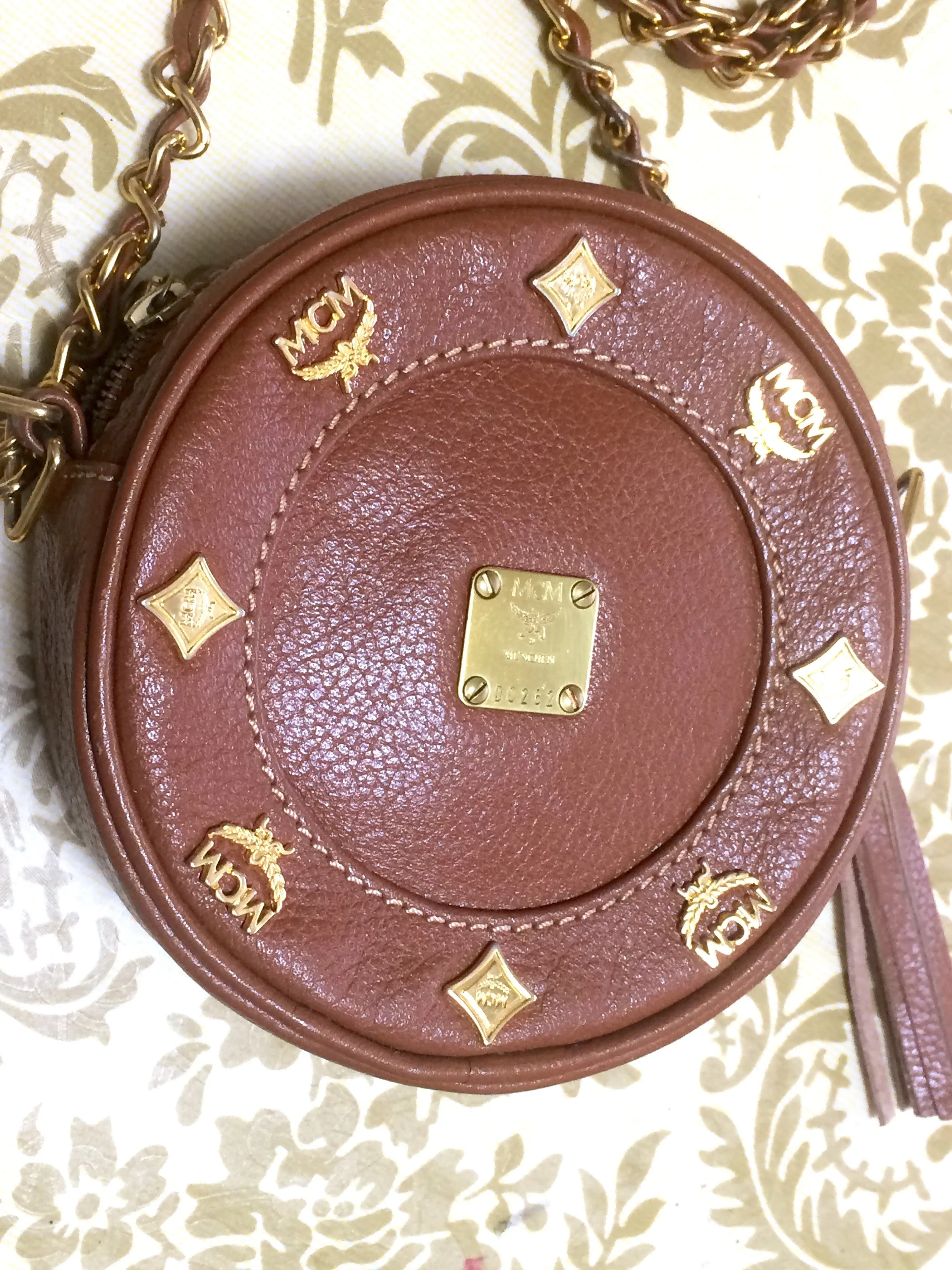 Vintage MCM brown leather round mini Suzy Wong shoulder bag with golden logo motifs. trimmings. Designed by Michael Cromer.